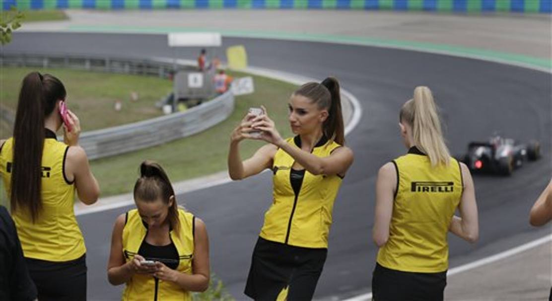 Mentre le grid girl fotografano la gara, il Gran Premio d’Ungheria del 27 luglio vede il miglior risultato stagionale della Ferrari con Alonso al secondo posto. Ricciardo vince la gara. Hamilton giunge terzo. (Ap)